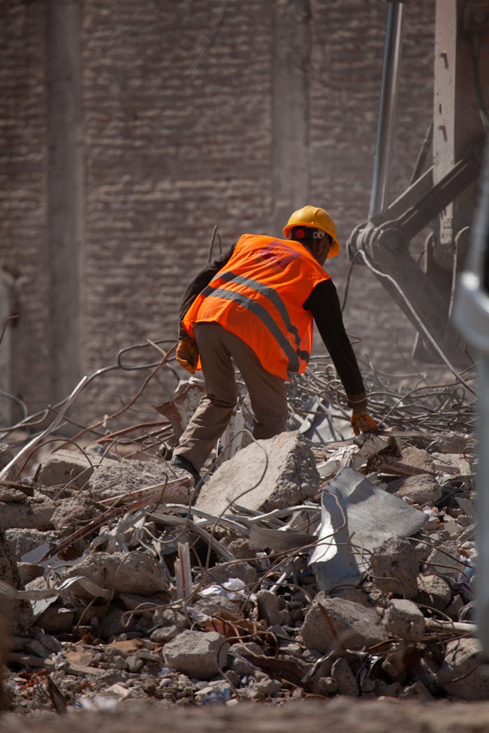 services-03 Worker wearing a helmet and vest clearing rubble in Malatya, Türkiye.